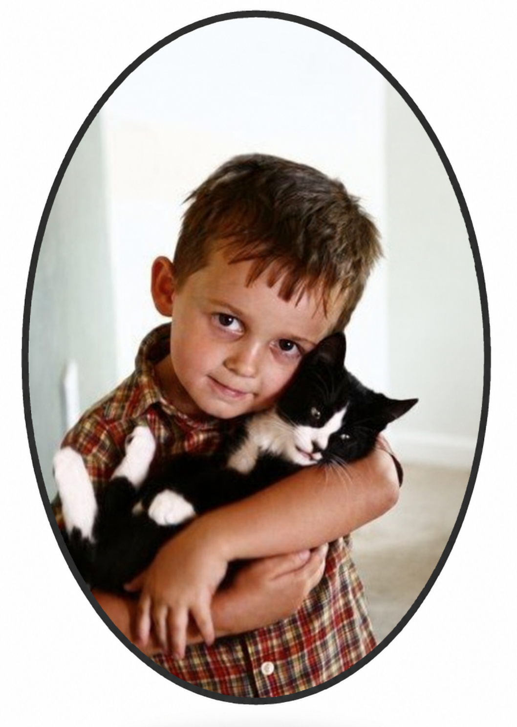 David at about five years old, holding a black-and-white cat in his arms.